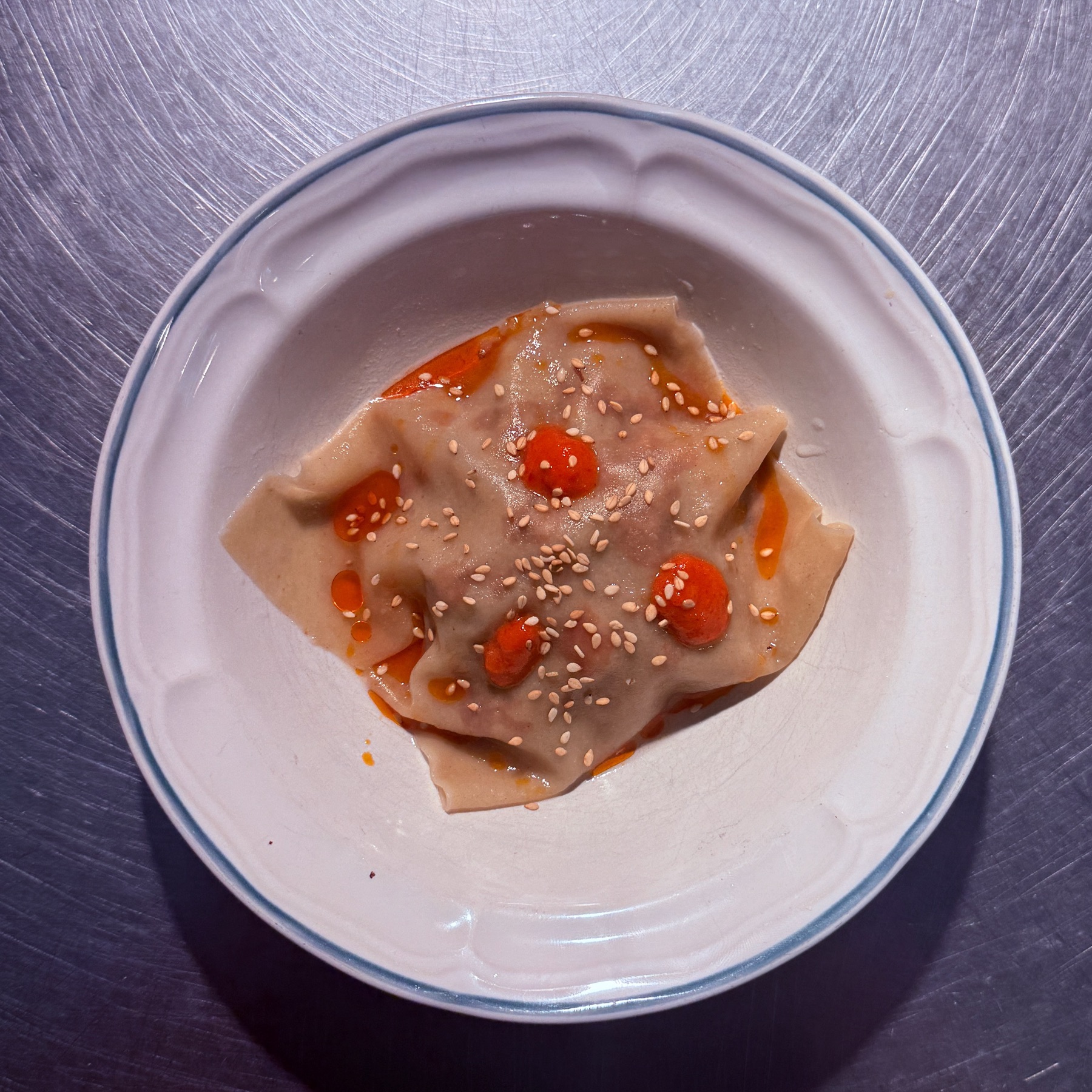 Raviole de porc et veau épicés, bouillon pho, condiment poivrons au miel et huile d'olive