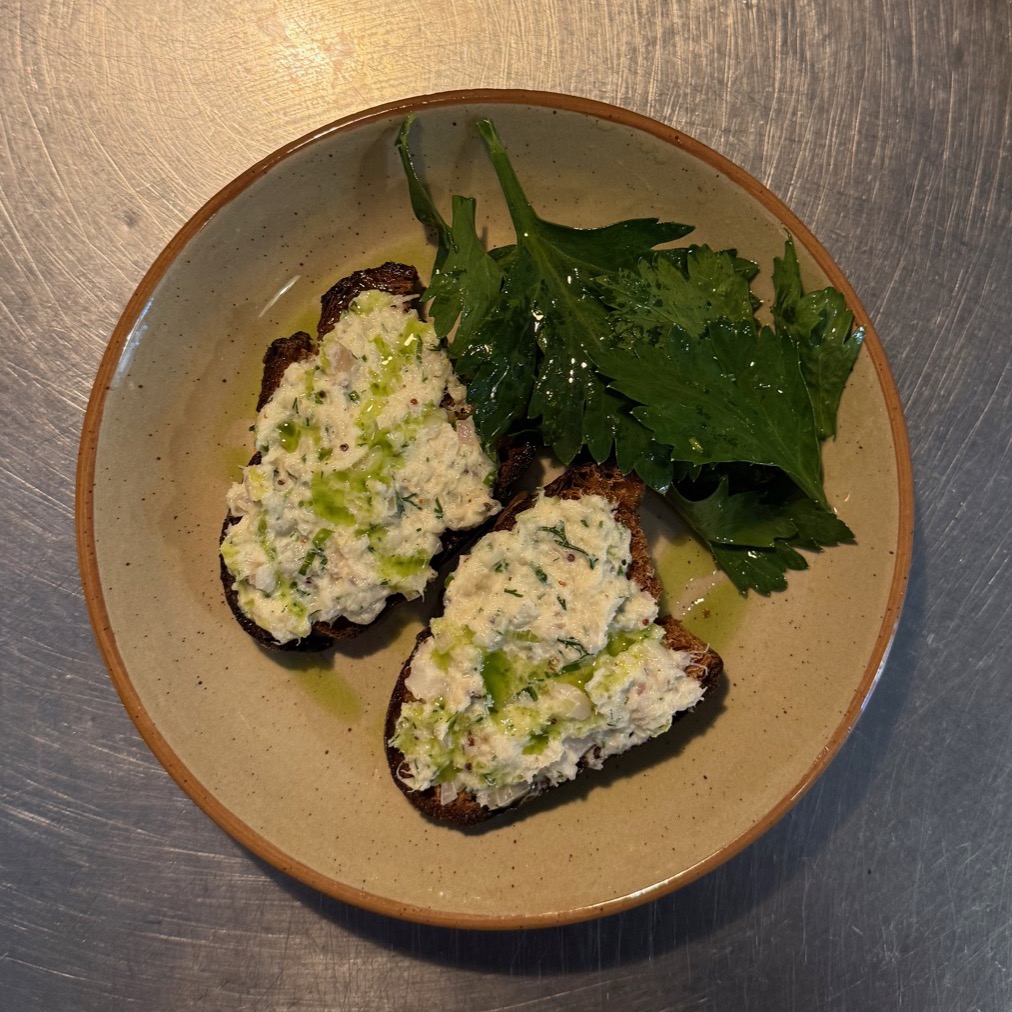 Tartines de pain de campagne aux rillettes de poisson, feuilles de céleri aux herbes